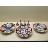 Four small Imari bottle vases and three Imari plates, all generally good, chips to one plate