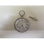 A silver pocket watch with 5.2cm case in running order, generally good some wear to case, with key