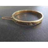 A hallmarked 9ct yellow gold hollow hinged bangle, 6cm x 6.5cm, approx 9.7 grams, minor denting