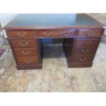 A late Victorian / Edwardian mahogany twin pedestal nine drawer desk with a leather inset top,