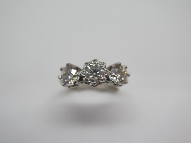 A hallmarked 18ct white gold three stone diamond ring, the outer diamonds approx 0.55ct each, the