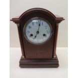 An 8 day mahogany case striking mantle clock, 33cm tall, some small inlay loss but running