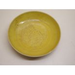 A Chinese yellow incised dragon saucer dish, possibly 18th Century ,11cm diameter, small chip to rim