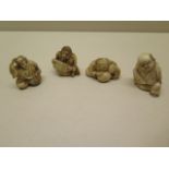Four Japanese Meiji seated carved ivory netsukes, tallest 4cm, some age related cracks otherwise