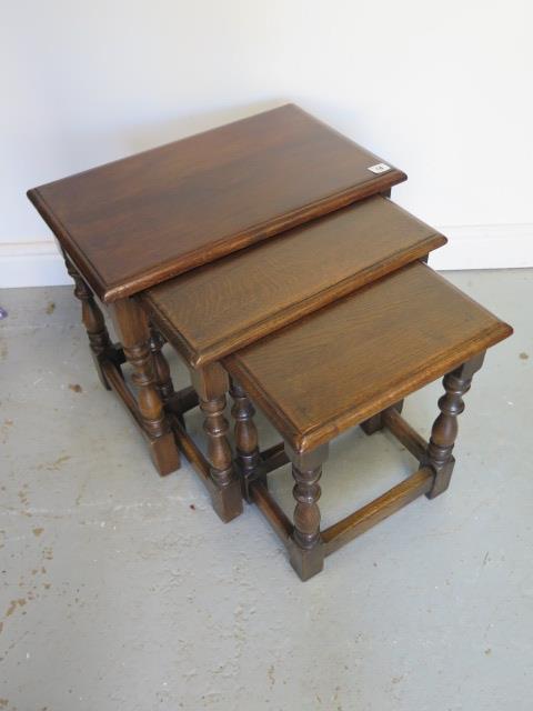 A nest of three oak coffee tables, 48cm tall x 55cm x 35cm