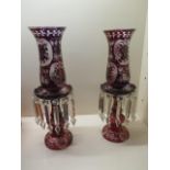 A pair of ruby glass candle lustres, 45cm high, converted to electric, one long drop missing,