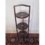 An Edwardian inlaid three tier folding cake stand