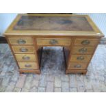 An Edwardian mahogany nine drawer one piece kneehole desk with an inset top, 74cm tall x 107cm x