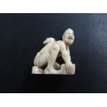 A well carved antique Japanese Meiji netsuke of a seated man with a rat on his back, 3.5cm x 3cm,