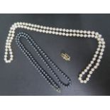 A string of pearls, 88cm long, with a 14ct yellow gold diamond and ruby separate clasp and a 75cm