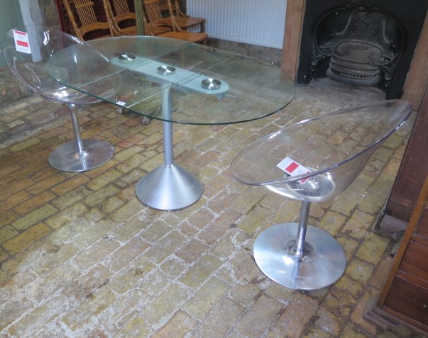 A glass and metal dropleaf breakfast table and a pair of Phillippe Starck design perspex swivel