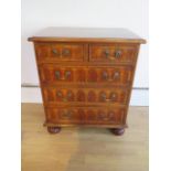 A yew oyster veneer chest of small proportions with two short over three long drawers on turned feet
