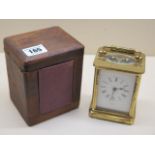 A brass carriage clock 11 cm tall with travel case, in working order, glass good