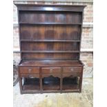 An 18th Century and later Oak dresser with an open rack top above three drawers and a pot board base