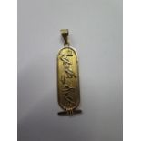 An 18ct gold 36mm long Egyptian scroll pendant, approx 2.64 grams, in good condition, minor usage