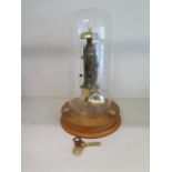 A Franz Hermle brass skeleton clock under a glass dome with key, working order, 30cm tall