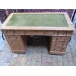 A late Victorian stripped pine nine drawer twin pedestal desk with a leather insert top, 72cm tall x