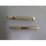 Two hallmarked gold tie clips, 6cm and 5.5cm long, one set with a small diamond, some usage but