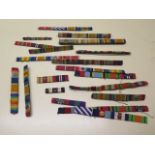 Twenty medal ribbons WWI-WWII, all with emblems including one Battle of Britain rosette -