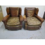 A pair of tan leather deep seated club wingback armchairs with brass studwork, 86cm tall x 85cm deep