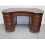 A good quality marquetry inlaid kidney shape desk, with 9 drawers and a leather inset top, the whole