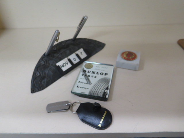 A collection of Dunlop advertising desk items, paperweights, key ring, pen knives, tyre perpetual
