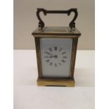 A brass 8 day French carriage clock, 15cm tall, in running order, glass good