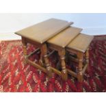 A nest of three oak side tables