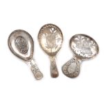 A small collection of three antique silver caddy spoons, all with oval bowls, pierced decoration and