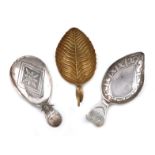 A small collection of three antique silver caddy spoons, comprising: a silver-gilt one of leaf form,