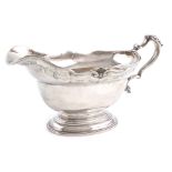 A silver sauce boat, by Charles Stuart Harris, London 1920, oval form, scroll and shell border, with