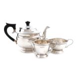 A matched three-piece silver tea set, the teapot by E. Viner, Sheffield 1935, the cream and sugar by