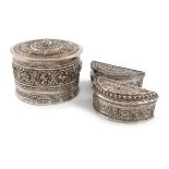 Three Burmese silver betel nut boxes, comprising: one of circular form, chased with signs of the