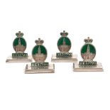 A set of four silver and enamel menu card holders, Birmingham 1919, modelled as the badge of the