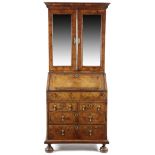 A GEORGE I WALNUT BUREAU BOOKCASE C.1715-20 with cross and feather banding, the moulded cornice