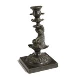 A REGENCY BRONZE CANDLE / TAPERSTICK C.1810-20 in the form of a dolphin supporting an urn shape