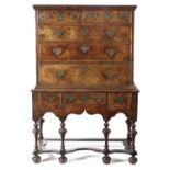 A QUEEN ANNE WALNUT CHEST ON STAND C.1710 with two short and three long feather banded drawers,