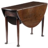 A GEORGE II MAHOGANY DINING TABLE C.1740 the oval drop-leaf top on turned club legs, with unusual