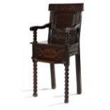 A WILLIAM AND MARY OAK CHILD'S HIGHCHAIR C.1690 the panelled back carved with scrolling tulips and
