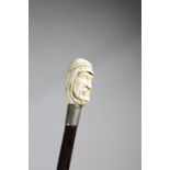 λ AN EDWARDIAN IVORY HANDLED WALKING CANE C.1910 carved with an Arab's head, above a silver collar