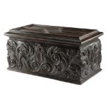A WILLIAM IV OAK TEA CHEST C.1830 carved with scrolling leaves, the hinged panelled top revealing