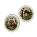 A PAIR OF FOLK ART REVERSE GLASS OVAL MIRRORS EARLY 20TH CENTURY painted with a tiger and a lion,