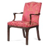 A GEORGE III MAHOGANY OPEN ARMCHAIR C.1770 with an arched padded back and seat, covered with