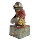 A GERMAN TIN PLATE MONKEY MONEY BOX PROBABLY BY MAIENTHAU & WOLF, EARLY 20TH CENTURY modelled with a