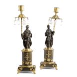 A PAIR OF REGENCY GILT AND PATINATED BRONZE FIGURAL CANDLESTICKS C.1815 each in the form of a