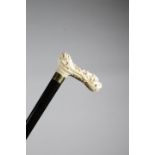 λ A FINE JAPANESE IVORY HANDLED CANE MEIJI 1868-1912 carved with a kylin head, flowers and leaves,