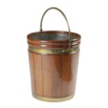 A GEORGE III MAHOGANY PEAT BUCKET PROBABLY IRISH, C.1800-10 of staved construction, with brass bands