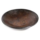 A TREEN STAINED ELM DAIRY BOWL 19TH CENTURY the exterior with moulded bands 46.5cm diameter