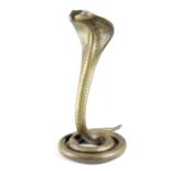 AN INDIAN BRASS MODEL OF A COBRA LATE 19TH CENTURY with glass eyes and punched decoration 32.5cm