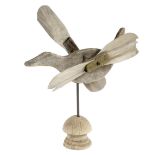 A FOLK ART CARVED WOOD WHIRLIGIG in the form of a flying duck, with ash propellers, on a turned wood